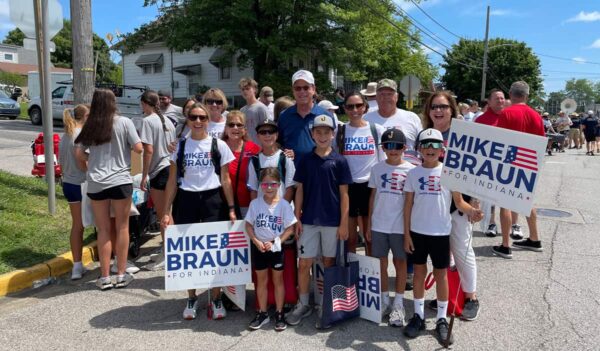 man stands with people to campaign