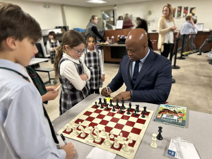 Maurice-Ashley_parental-permission-granted Maurice Ashley signs autographs and plays chess with St. Richard’s students during their lunch break. (Photo/St. Richards Episcopal School)