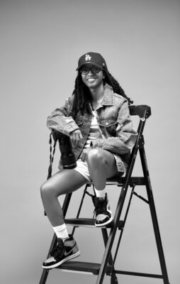 Mia Moore of She Shoots Photography sitting in a chair.