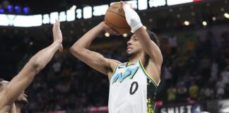 Indiana Pacers guard Tyrese Haliburton (0) shoots a three-point shot over Milwaukee Bucks forward Giannis Antetokounmpo (34) to tie the game late in the second half of an NBA basketball game in Indianapolis, Tuesday, March 11, 2025. (AP Photo/AJ Mast)