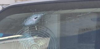 a bullet hole in the front windshieild of the Dirty Dozen Hunting and Fishing Club's commercial bus.
