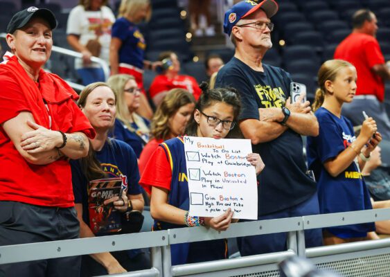 A WNBA fan almost has her checklist completed, hoping Fever forward Aliyah Boston (7) would honor her request (which she did after the game) during the WNBA game between the Los Angeles Sparks and Indiana Fever on July 5, 2025, at Gainbridge Fieldhouse in downtown Indianapolis, Indiana. (Photo/David Dixon)