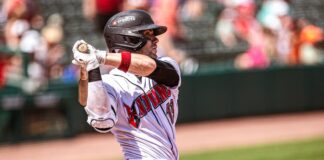 man swinging a baseball bat during a baseball game.