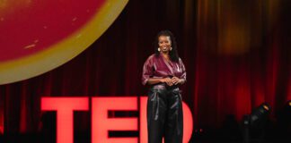 woman delivering a TED Talk during a TEDx event.