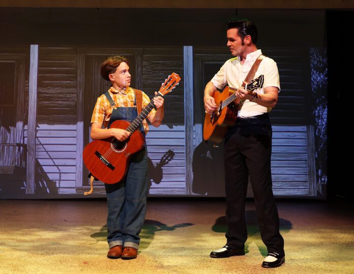 Elvis Presley (Nicholas Voss) watches his younger self (Henry Kirk) learn to play the guitar i n Beef & Boards Dinner Theatre's production of Heartbreak Hotel, now on stage through Oct. 12.