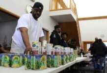 Volunteers stack canned goods at Fountain Square Church of Christ on the Southeast side of Indianapolis during a food distribution event Saturday, Nov. 8, 2025 organized by the city’s Office of Public Health and Safety. (Photo via WFYI)