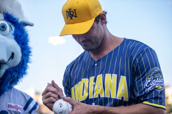A participant signs a softball for a fan with the Indianapolis Colts mascot, Blue, standing nearby. (Photo/Josh Herd)