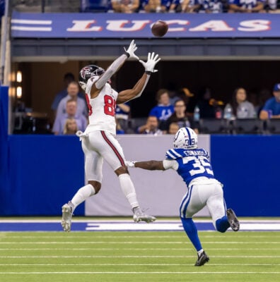 An Atlanta Falcons wide receiver leaps for a high pass while being tightly covered by Indianapolis Colts defensive back Johnathan Edwards (#35).