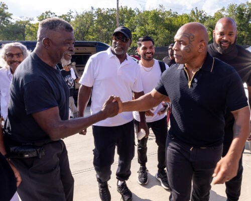 Photo 1: Former undisputed world heavyweight champion Mike Tyson (right) greets attendees outside upon arriving for a youth boxing workshop on Aug. 28, 2026, at The Right Jab boxing gym, located at 3737 Sutherland Ave, in Indianapolis. (Photo/Walt Thomas)