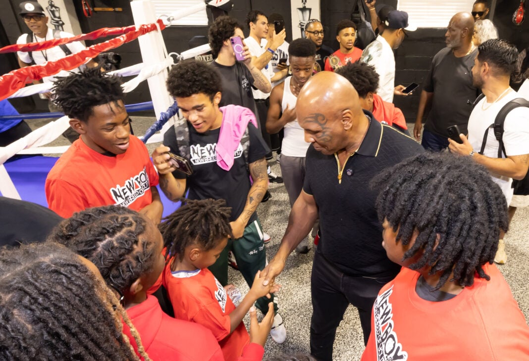Photo 6: Mike Tyson gathers with a group of young fighters and community members inside the gym to offer encouragement and ring advice on Aug. 28, 2026, at The Right Jab boxing gym, located at 3737 Sutherland Ave, in Indianapolis. (Photo/Walt Thomas)