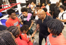 Photo 6: Mike Tyson gathers with a group of young fighters and community members inside the gym to offer encouragement and ring advice on Aug. 28, 2026, at The Right Jab boxing gym, located at 3737 Sutherland Ave, in Indianapolis. (Photo/Walt Thomas)