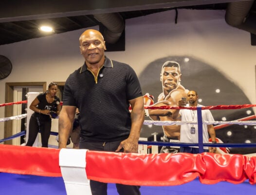Mike Tyson steps between the ropes in front of a wall mural of himself, preparing to speak to local youth during the weekend clinic on Aug. 28, 2026, at The Right Jab boxing gym, located at 3737 Sutherland Ave, in Indianapolis. (Photo/Walt Thomas)