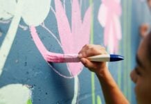 Braun designates September as Creative Economy Month Woman, hand or painting on wall art for mural, creativity or community service at building. Artist, paintbrush or outdoor with color for floral decor, creative process or flowers for aesthetic design