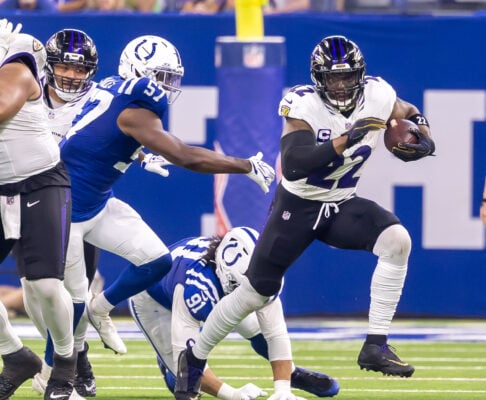 Baltimore Ravens running back Derrick Henry (#22) carries the ball downfield while evading tackles from Indianapolis Colts defenders, including Jaylon Carlies (#57) and Jaylahn Tuimoloau (#91), on Sept. 13, 2026, at Lucas Oil Stadium, in downtown Indianapolis, Indiana. (Photo/Walt Thomas)